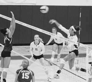 Senior Kristy Gilchrist (#20) spikes the ball over the heads and hands of the Wayne State team. Gilchrist has made over 1,000 kills over her career and has earned the title title of GLIAC North Division Player of the Week twice just this season. Photo By: Kristyn Sonnenberg | Photo Editor Senior Kristy Gilchrist (#20) spikes the ball over the heads and hands of the Wayne State team. Gilchrist has made over 1,000 kills over her career and has earned the title title of GLIAC North Division Player of the Week twice just this season. Photo By: Kristyn Sonnenberg | Photo Editor