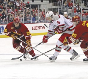 The Clash: Junior Mike Embach (#26) and freshman Matthew Kirzinger (#20) fight an Ohio State opponent for control of the puck last Saturday. Photo courtesy of Kathy Cubert, Ohio State University Lantern