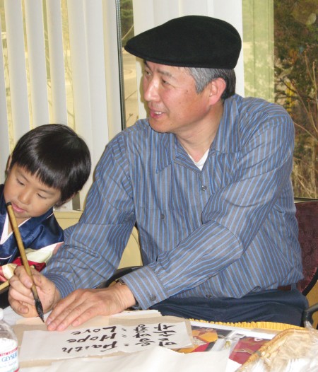 Inspiring words: Jung Choi, assistant professor at Ferris in the department of accountancy finance and information systems, shares his South Korean culture with students by writing out some uplifting words in Korean lettering at last year’s annual International Festival of Cultures. This Sunday, the Dome Room will again be bustling with dancing, a pinata, international foods and more. Photo courtesy of Shana Beisiegel
