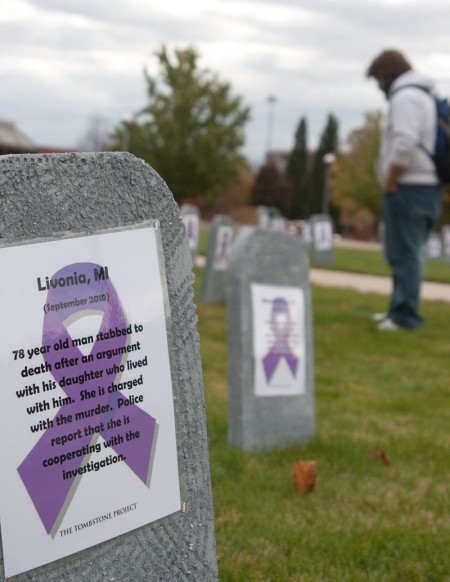 Domestic Violence Awareness: Michael Burlingame reads a part of the Tombstone Project, which is bringing awareness about domestic violence cases that have occurred the past few years in Michigan. Photo By: Kate Dupon | Photo Editor Domestic Violence Awareness: Michael Burlingame reads a part of the Tombstone Project, which is bringing awareness about domestic violence cases that have occurred the past few years in Michigan. Photo By: Kate Dupon | Photo Editor