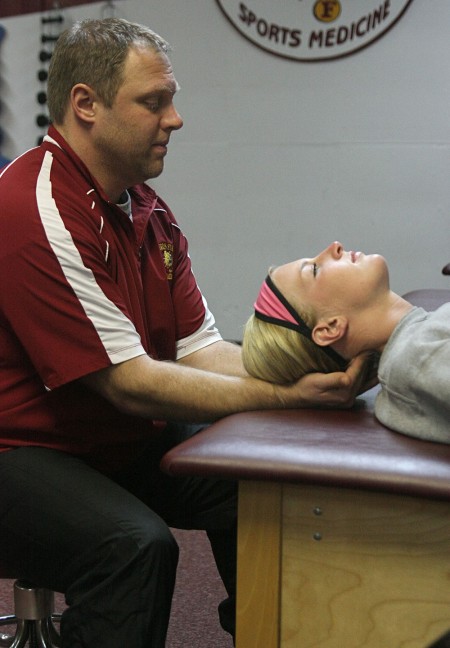 Behind the Scenes: Trainer Tim Glover helps stretch out Makenzi Peterson, a junior on the softball team. Trainers are the people behind the scenes that help Bulldog athletes stay healthy. Photo By: Michael Fleming | Web Editor Behind the Scenes: Trainer Tim Glover helps stretch out Makenzi Peterson, a junior on the softball team. Trainers are the people behind the scenes that help Bulldog athletes stay healthy. Photo By: Michael Fleming | Web Editor
