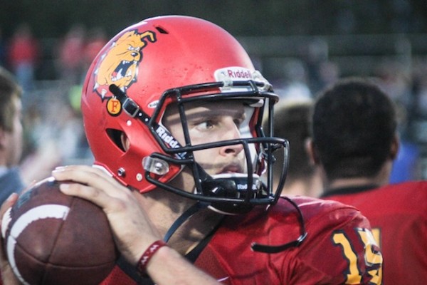 Junior quarterback Jason Vander Laan warms up on the sidelines during a game.