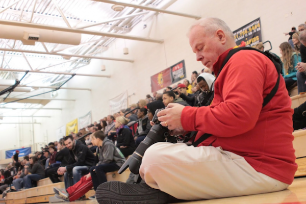 Ferris alum Kevin McDermott sits courtside with his camera as the Ferris basketball team plays at home.
